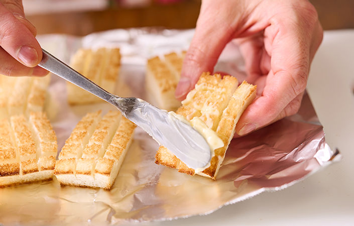 焼き目がついたパンにバターを塗る