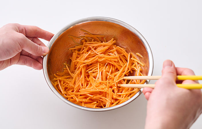 細切りにしたにんじんをボウルに入れて調味料を入れます