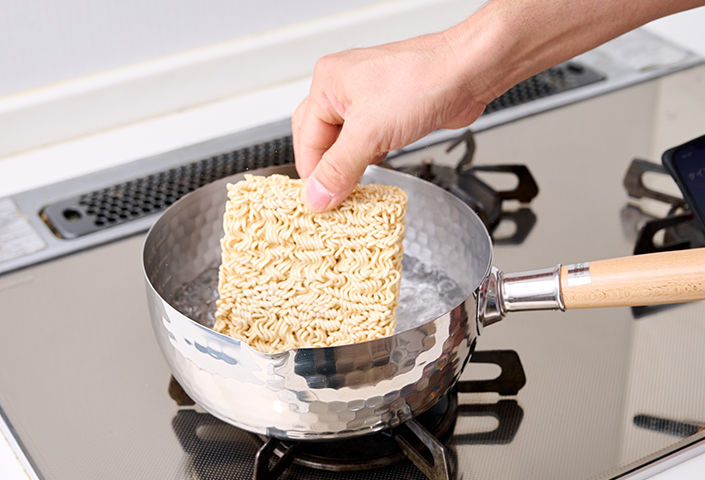 規定量の「お湯」を鍋に入れ、火をつけたら麺を投入します。