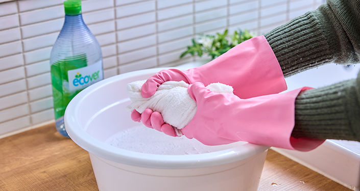 ぬいぐるみを洗うために洗浄液にタオルを浸す