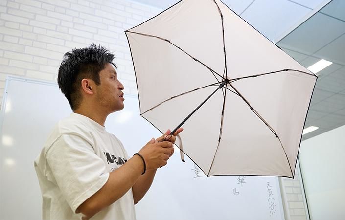 超軽量傘の親骨を確認する佐藤バイヤー