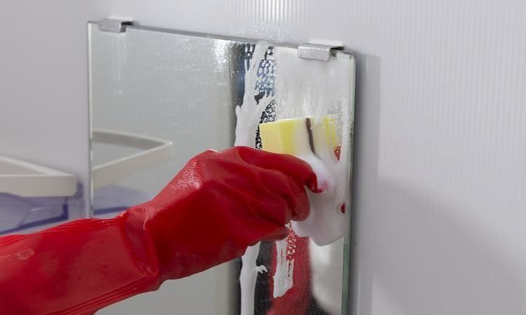 鏡を専用スポンジでこすり洗い